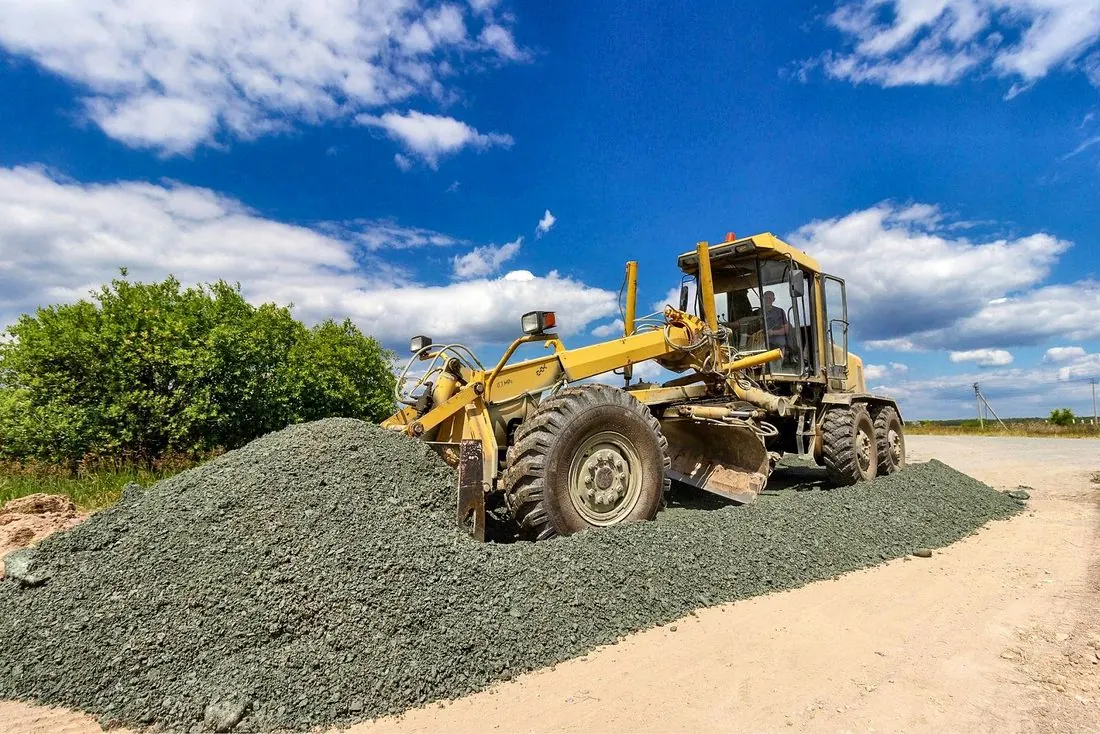 Motoniveladora conformando una vía con material granular